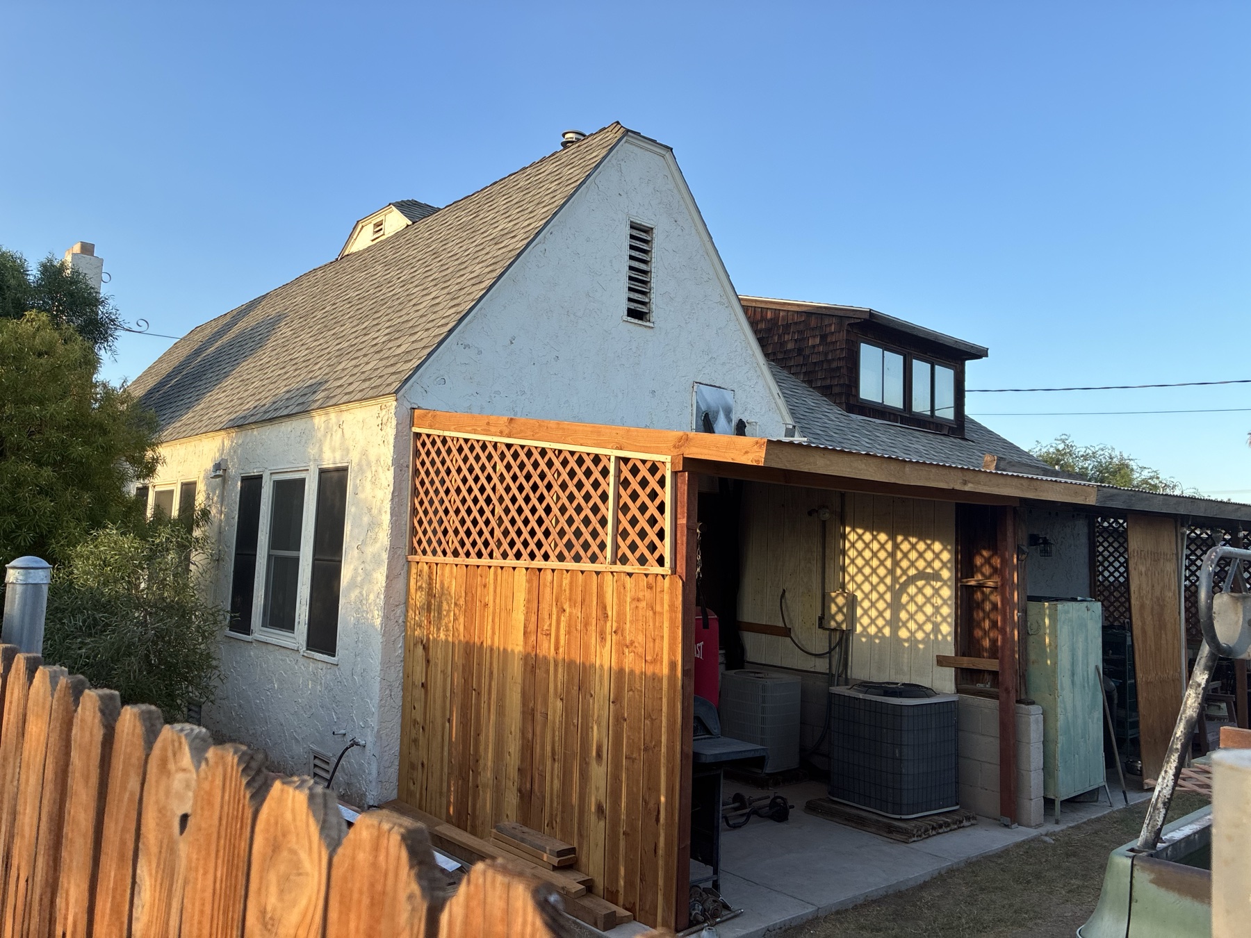 After: a covered outdoor room framed by wood privacy panels and lattice